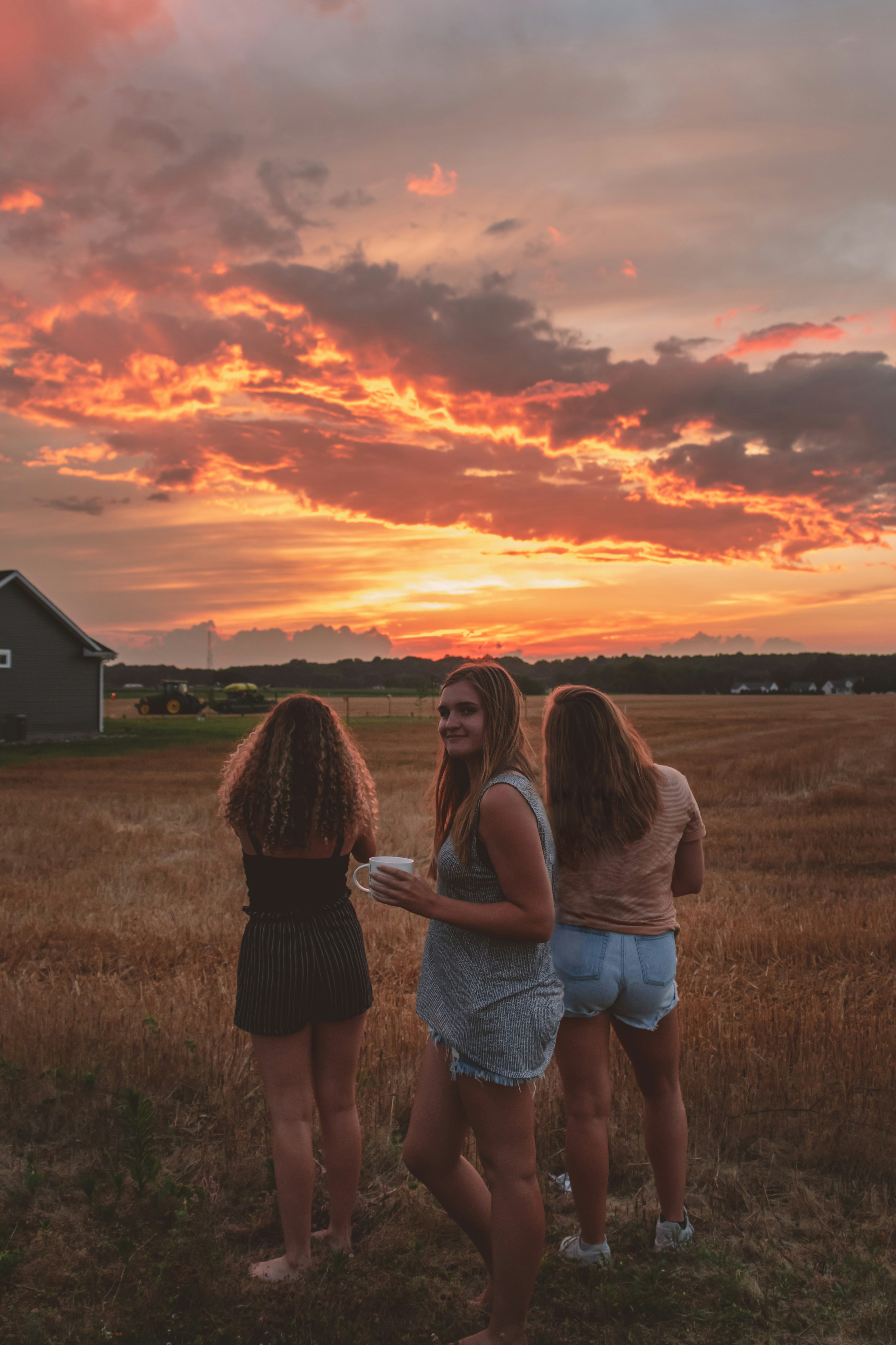 2 women standing on grass field during sunset